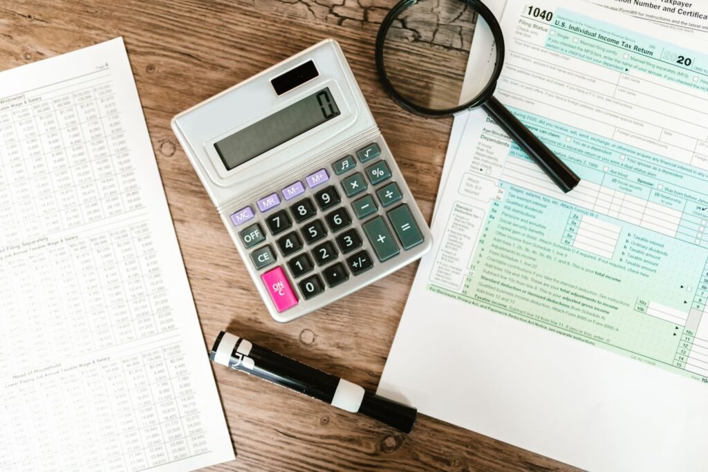 Calculator and magnifying glass on a wooden desk