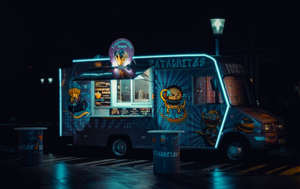 Colorful food truck lit up with neon lights at night
