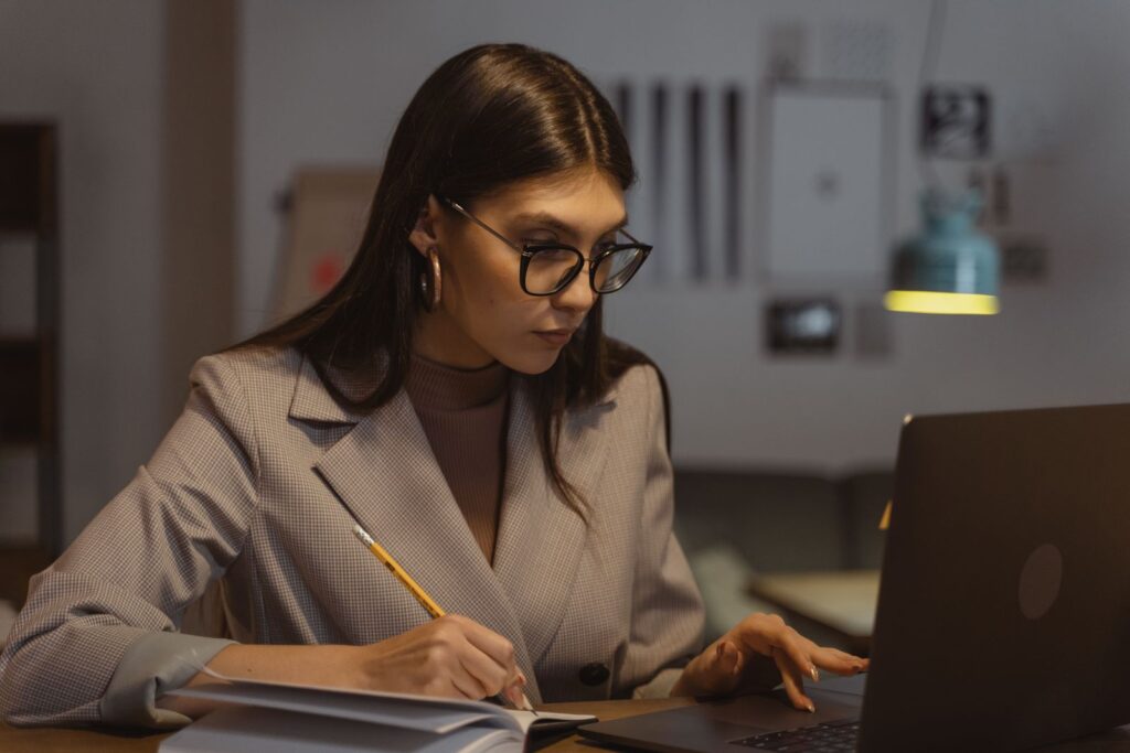 Freelancer working on a laptop and taking notes