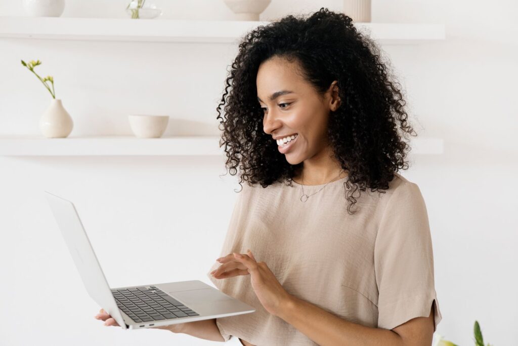 Smiling woman working on a laptop in her home office