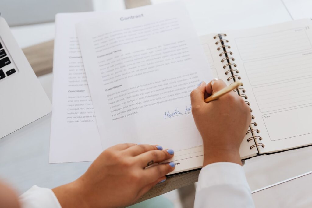 Business owner signing LLC formation documents at a desk