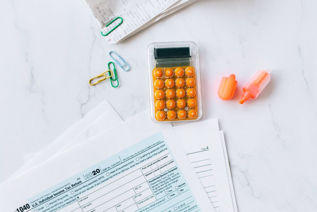 Tax forms, a calculator, and office supplies on a desk