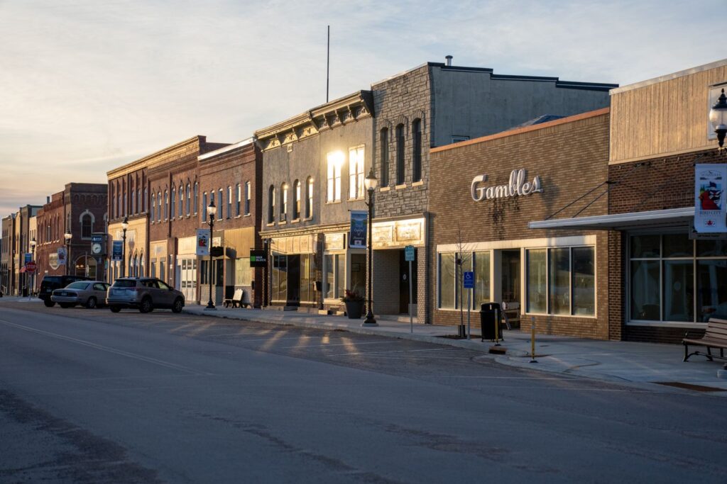 Historic main street storefronts in a small Midwestern town at sunset