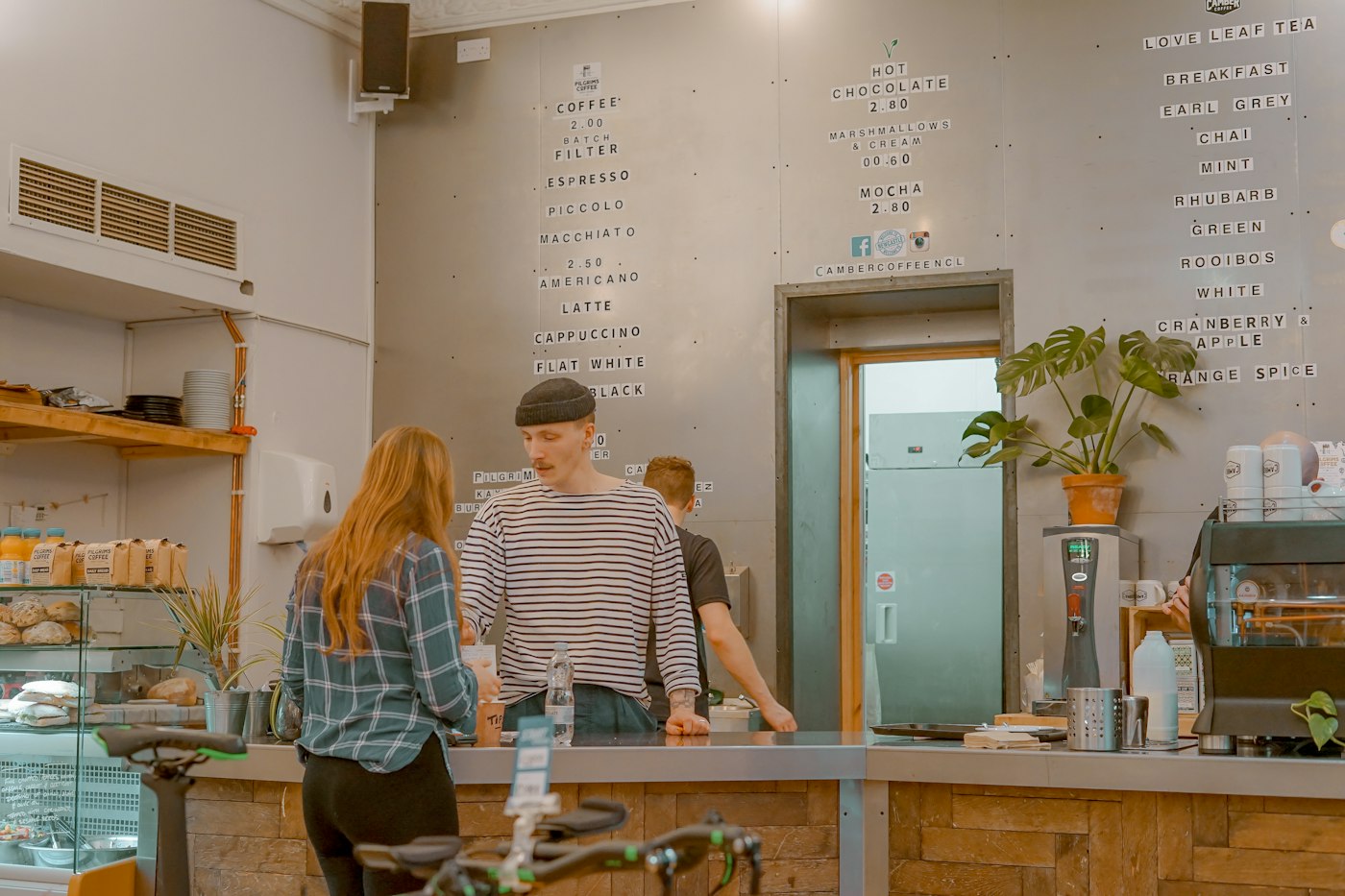 Customer chatting with staff at a coffee shop counter
